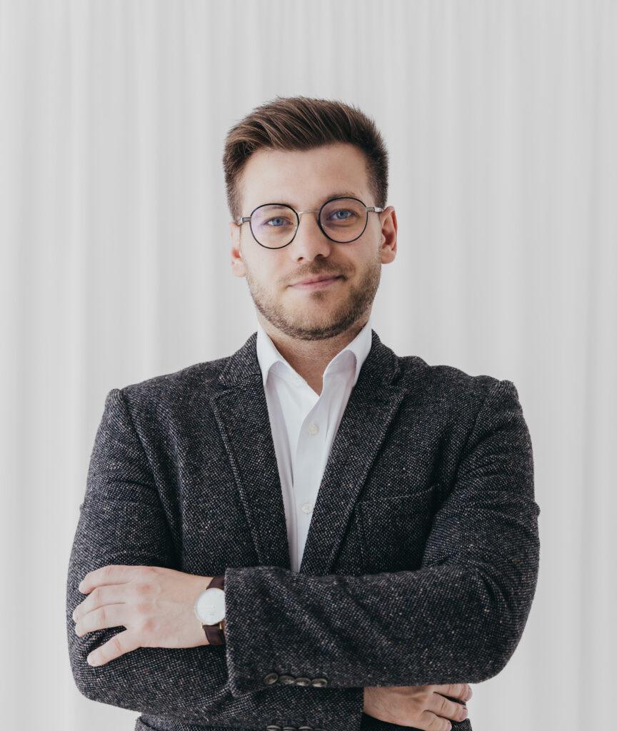 Man in a suit wearing round glasses