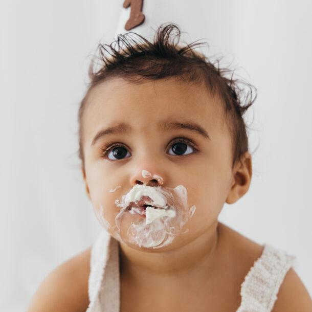 baby portrait in first birthday cake smash session in bright white studio