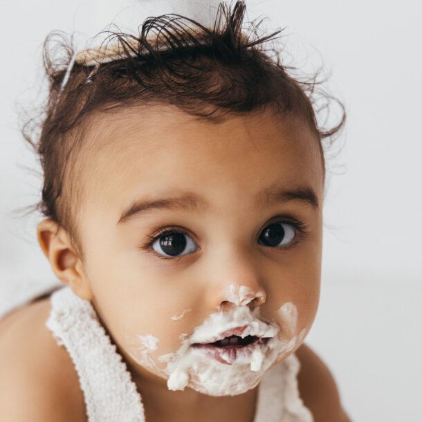 baby portrait in first birthday cake smash session in bright white studio